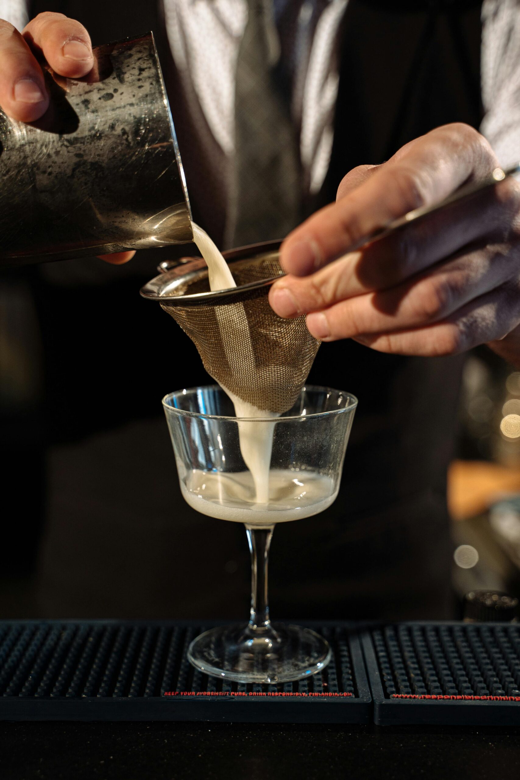 Person Pouring Alcoholic Drink in Clear Glass